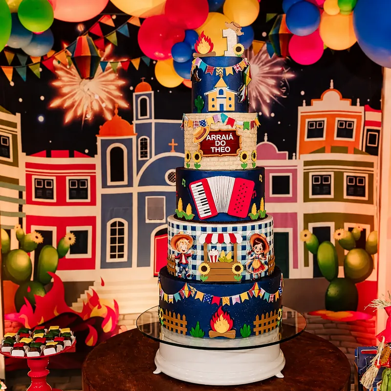Bolo de aniversário temático de arraiá com sanfona, bandeirinhas e casinhas coloridas